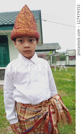 little boy in a kimono shirt and hat 127474352