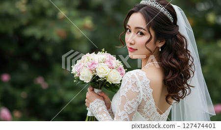 A bride in a white wedding dress holding a bouquet and turning around at a garden wedding A bride in a white wedding dress holding a bouquet and turning around at a garden wedding 127474401