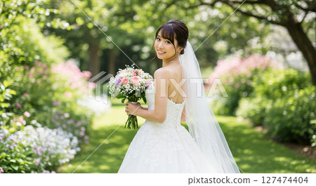 一位身穿白色婚紗的新娘在花園婚禮上手捧花束轉身 一位身穿白色婚紗的新娘在花園婚禮上手捧花束轉身 127474404