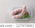Raw wieners on a plate 127474661