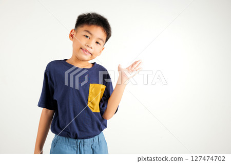 Asian happy portrait cute young boy smile presenting product holding something on palm away side, studio shot isolated on white background with copy space, primary child show hand gesture 127474702