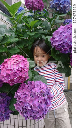 A boy posing in front of flowers A boy posing in front of flowers 127475219