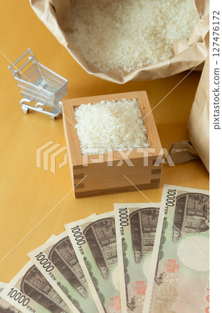 Rice in a measuring box, a rice bag, a shopping cart, and a 10,000 yen note - an image of the price of rice 127476172