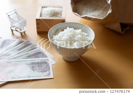 Rice in a bowl, a 10,000 yen note, rice in a measuring box, a bag of rice, and a shopping cart. Images of rice prices Rice in a bowl, a 10,000 yen note, rice in a measuring box, a bag of rice, and a shopping cart. Images of rice prices 127476174