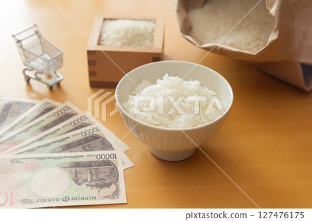 Rice in a bowl, a 10,000 yen note, rice in a measuring box, a bag of rice, and a shopping cart. Images of rice prices Rice in a bowl, a 10,000 yen note, rice in a measuring box, a bag of rice, and a shopping cart. Images of rice prices 127476175