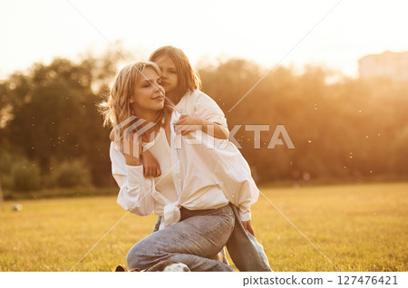 Conception of love, embracing each other. Woman with her little daughter are on the summer field together Conception of love, embracing each other. Woman with her little daughter are on the summer field together 127476421
