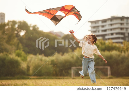 Little girl is playing with kite on the field 127476649