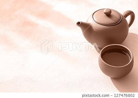 A rustic mocha mousse clay teapot and cup on a soft copy space background. Modern trendy tone hue shade 127476802