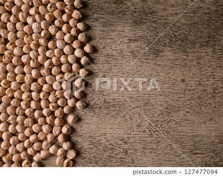 Raw Chickpeas on a rustic wooden table. Dry chickpea background close up. Chickpea legumes seed background. Raw Chickpeas on a rustic wooden table. Dry chickpea background close up. Chickpea legumes seed background. 127477094