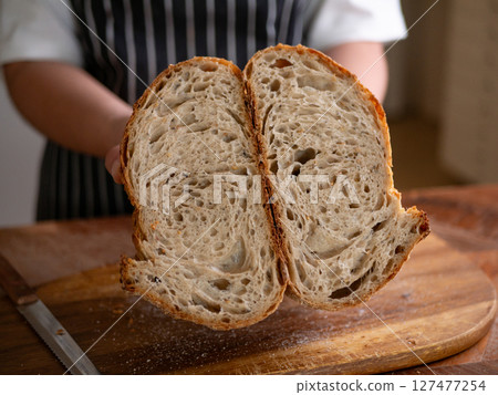 Artisan Sourdough Bread in Hand Fresh from the Oven. 127477254