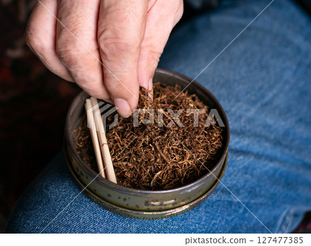 Preparing rolled cigarettes with dried tobacco. 127477385