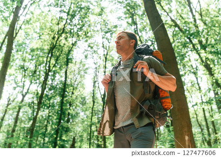 Beautiful sunlight through the trees. Tourist in summer forest. Conception of exploration and leisure 127477606