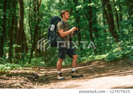 Beautiful sunlight through the trees. Tourist in summer forest. Conception of exploration and leisure 127477623