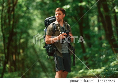 Navigation conception. With binoculars. Tourist in summer forest 127477625