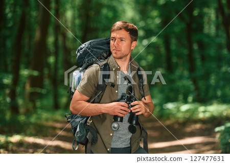 Navigation conception. With binoculars. Tourist in summer forest 127477631