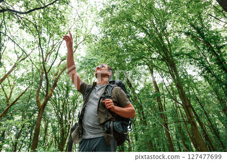 In sunglasses. Tourist in summer forest. Conception of exploration and leisure In sunglasses. Tourist in summer forest. Conception of exploration and leisure 127477699