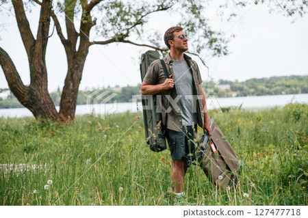 Tourist is outdoors near the lake. Conception of exploration and leisure Tourist is outdoors near the lake. Conception of exploration and leisure 127477718