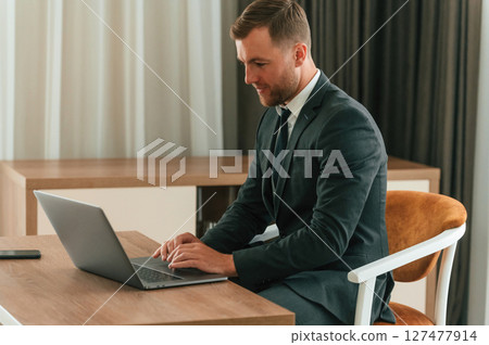 Handsome businessman is indoors in the hotel room 127477914