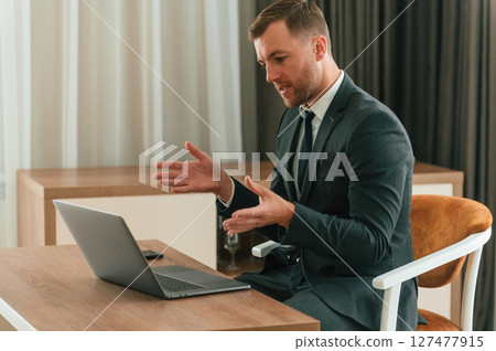Handsome businessman is indoors in the hotel room Handsome businessman is indoors in the hotel room 127477915