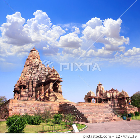 Kandariya Mahadeva Temple, Khajuraho, Madya Pradesh, India. Topic of vacation, travel, trip abroad, cruises, tours. Temple Complex in Khajuraho is prominent symbol of India and key tourist attraction Kandariya Mahadeva Temple, Khajuraho, Madya Pradesh, India. Topic of vacation, travel, trip abroad, cruises, tours. Temple Complex in Khajuraho is prominent symbol of India and key tourist attraction 127478139
