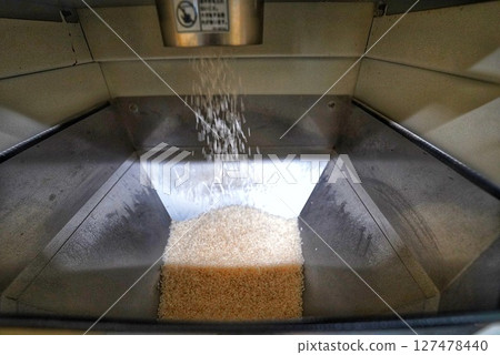 使用投幣式碾米機碾磨糙米 使用投幣式碾米機碾磨糙米 127478440