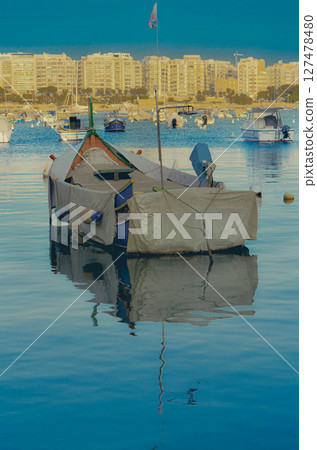 Traditional Fishing Boat Anchored in a Maltese Harbor at Sunset 127478480
