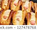 Freshly baked hot dog and sausage buns lined up in a bakery 127478768