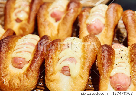 Freshly baked hot dog and sausage buns lined up in a bakery 127478768