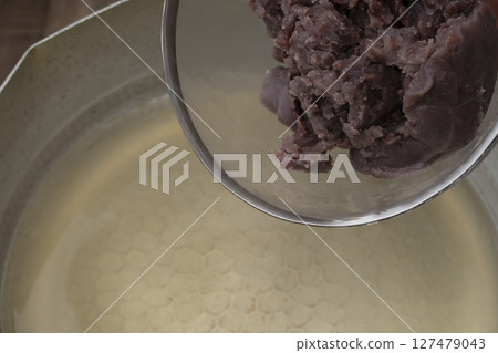 The process of making the summer Japanese sweet Mizu Yokan: Adding the red bean paste 127479043