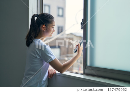 一個女孩在體育課上看她的智慧型手機 127479962