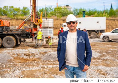 Supervisor overseeing soil sampling and pile drilling process on construction site. Responsible specialist ensuring quality control and compliance during geotechnical operations 127480302