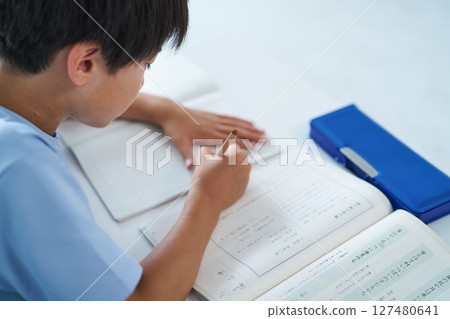A boy studying hard A boy studying hard 127480641