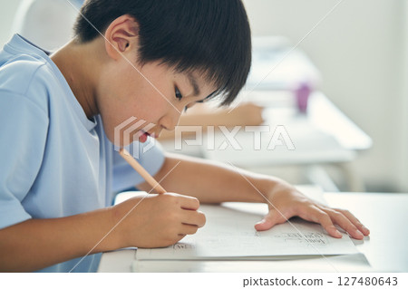 A boy studying hard 127480643