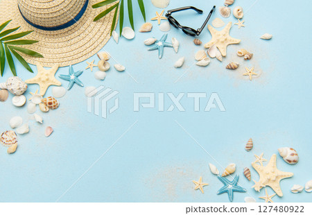 Beach accessories creating a summer holiday background on light blue copy space 127480922
