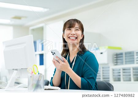 Business woman using a smartphone in the office Business woman using a smartphone in the office 127480982