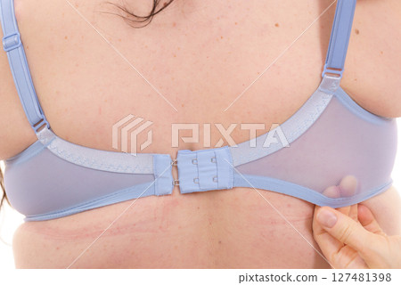 Bra fitter help plus size woman find perfect fit. Back view. 127481398