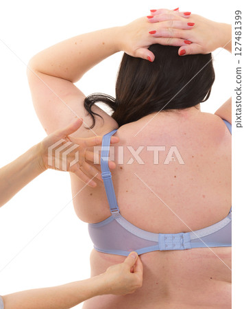 Bra fitter help plus size woman find perfect fit. Back view. 127481399