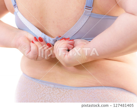 Woman back view putting on her bra lingerie. Woman back view putting on her bra lingerie. 127481405