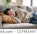 A woman in her 30s lying down in pain from menstrual cramps 127481497