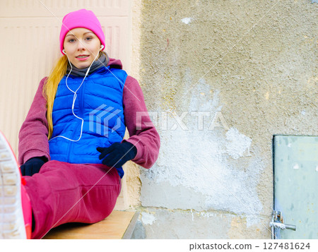 Woman wearing warm sportswear relaxing after exercising Woman wearing warm sportswear relaxing after exercising 127481624