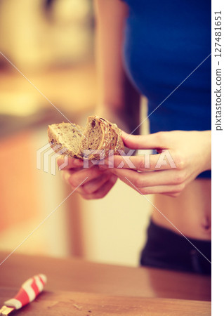 Woman making sandwich cutting bread 127481651