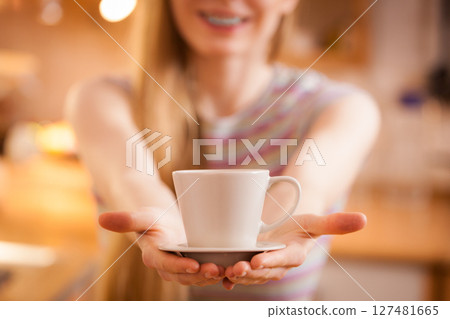 Happy woman holding cup of tea of coffee Happy woman holding cup of tea of coffee 127481665