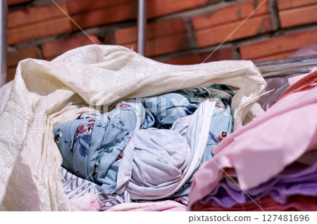 Colorful Fabric Rolls in a Sack Against Textured Brick Wall Colorful Fabric Rolls in a Sack Against Textured Brick Wall 127481696