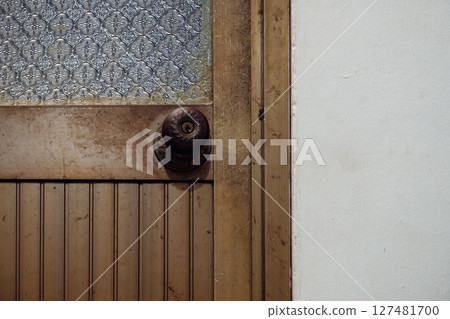 Old metal door with a vintage glass panel and knob Old metal door with a vintage glass panel and knob 127481700