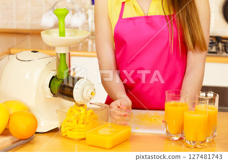 Woman pouring orange juice drink in glass 127481743