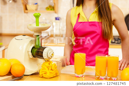 Woman pouring orange juice drink in glass 127481745