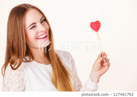 Beautiful woman holding heart shaped hand stick Beautiful woman holding heart shaped hand stick 127481762