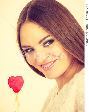 Beautiful woman holding heart shaped hand stick Beautiful woman holding heart shaped hand stick 127481764