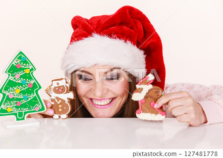 Woman santa claus hat with gingerbread cookies. Christmas 127481778