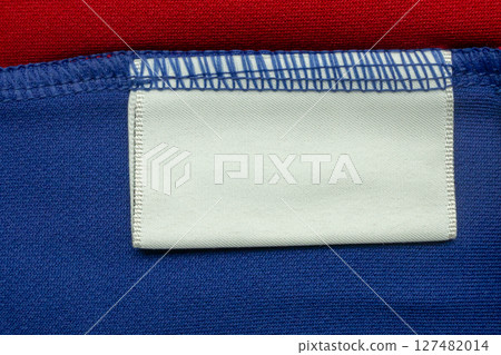 White blank laundry care clothes label on blue shirt fabric background White blank laundry care clothes label on blue shirt fabric background 127482014